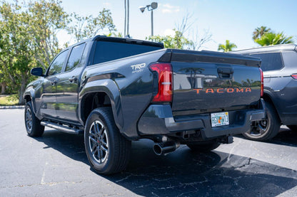 Black vinyl TACOMA tailgate inlay letters for 2024+ Toyota Tacoma, exterior decal by StickerFab on a truck tailgate.