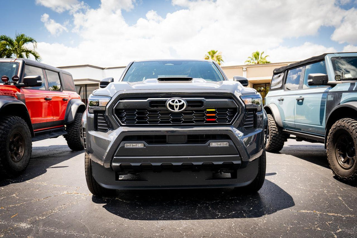 TRD Style Heritage Grille Tri Bar Overlays for 2024+ Toyota Tacoma, vinyl exterior accessory by StickerFab, shown on vehicle front.