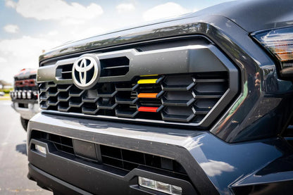 TRD style heritage grille tri bar overlays for 2024+ Toyota Tacoma, vinyl exterior accessory by StickerFab, shown on vehicle.