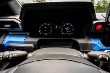 Vinyl interior dash overlays with topographic map design for 2024+ Toyota Tacoma, made by StickerFab, shown on dashboard.