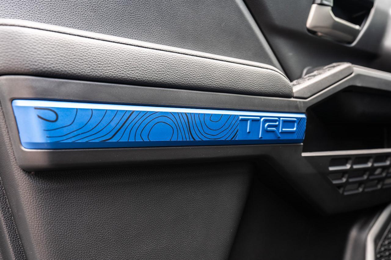 Vinyl interior door overlay featuring topographic map design for 2024+ Toyota Tacoma by StickerFab.
