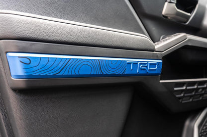 Vinyl interior door overlay featuring topographic map design for 2024+ Toyota Tacoma by StickerFab.