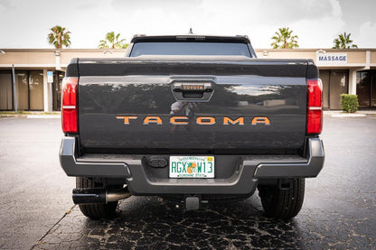 Tailgate handle inlay letters with standard vinyl on a 2024+ Toyota Tacoma exterior, featuring StickerFab branding.