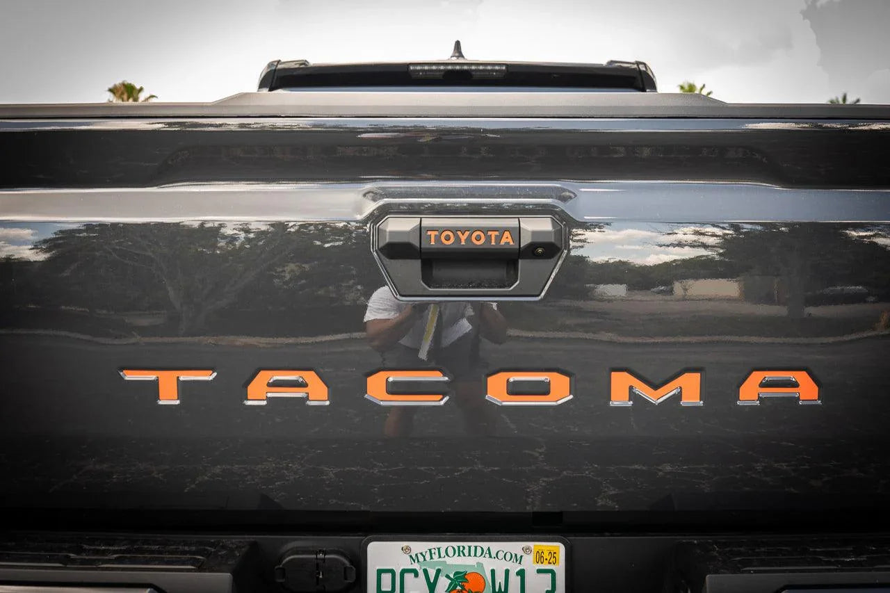 2024+ Toyota Tacoma tailgate handle inlay letters with standard vinyl exterior decal by StickerFab, featuring black text on tailgate.