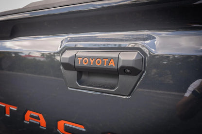 Vinyl tailgate handle inlay letters for 2024+ Toyota Tacoma, exterior sticker by StickerFab, shown on vehicle tailgate.
