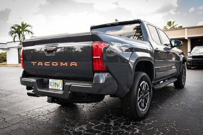 2024+ Toyota Tacoma tailgate handle inlay with standard vinyl letters, exterior StickerFab decal on vehicle tailgate.