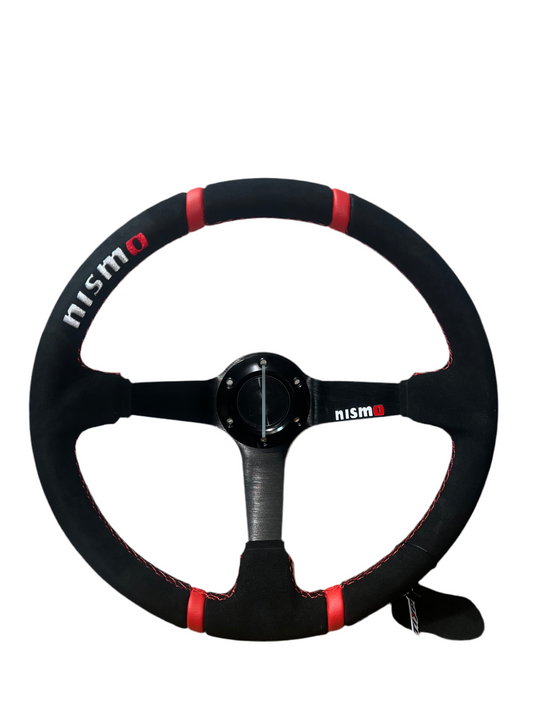 Speedzone Performance LLC Nismo steering wheel showing a close-up view of the sporty black steering wheel with textured grip and Nismo branding.
