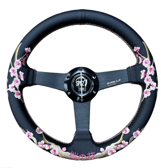Speedzone Performance LLC SPDZ1 Sakura steering wheel with black grip and silver accents, showing detailed close-up of the wheel's design.