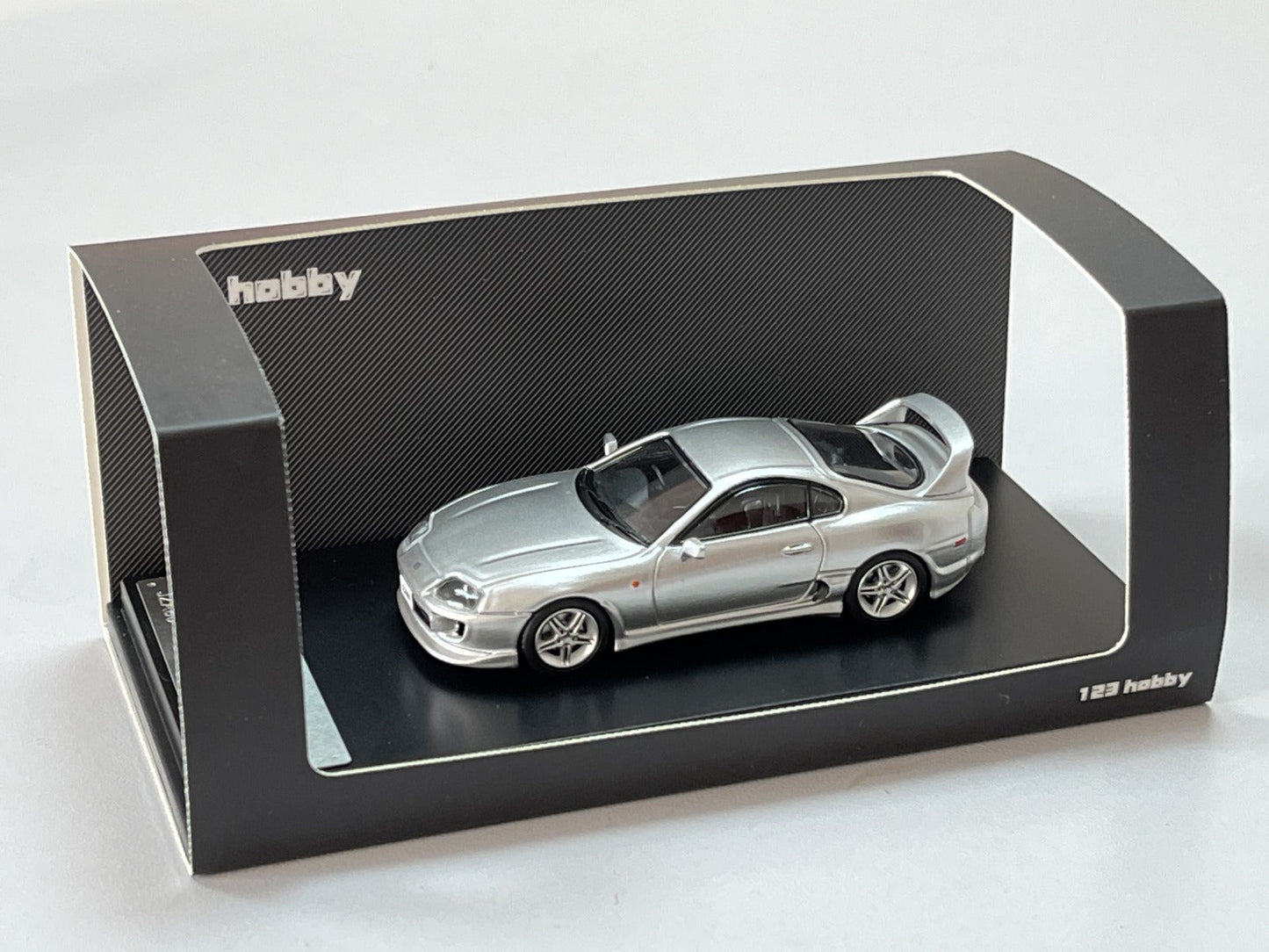 Silver 1:64 scale Toyota Supra JZA80Z diecast model by Lot57Supplies, detailed close-up of the toy car's exterior and design.