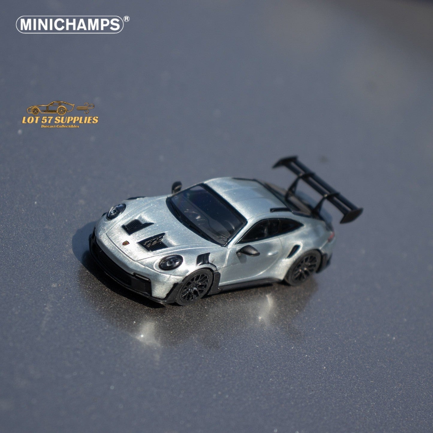 Silver diecast Porsche 911 GT3 RS model car in 1:64 scale by Minichamps, detailed miniature sports car for collectors.