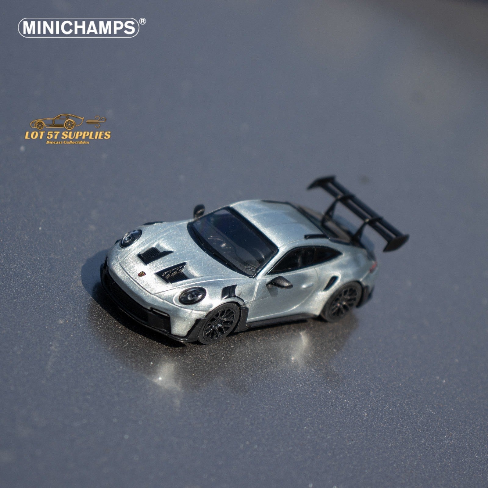 Silver diecast Porsche 911 GT3 RS model car in 1:64 scale by Minichamps, detailed miniature sports car for collectors.
