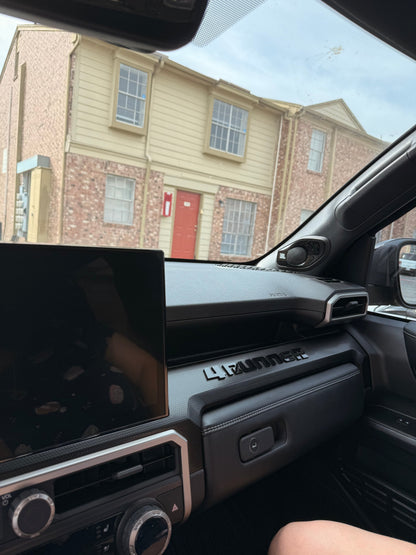 Vinyl interior dash letters spelling "4RUNNER" with template for 2025+ Toyota 4Runner, displayed on a vehicle dashboard.