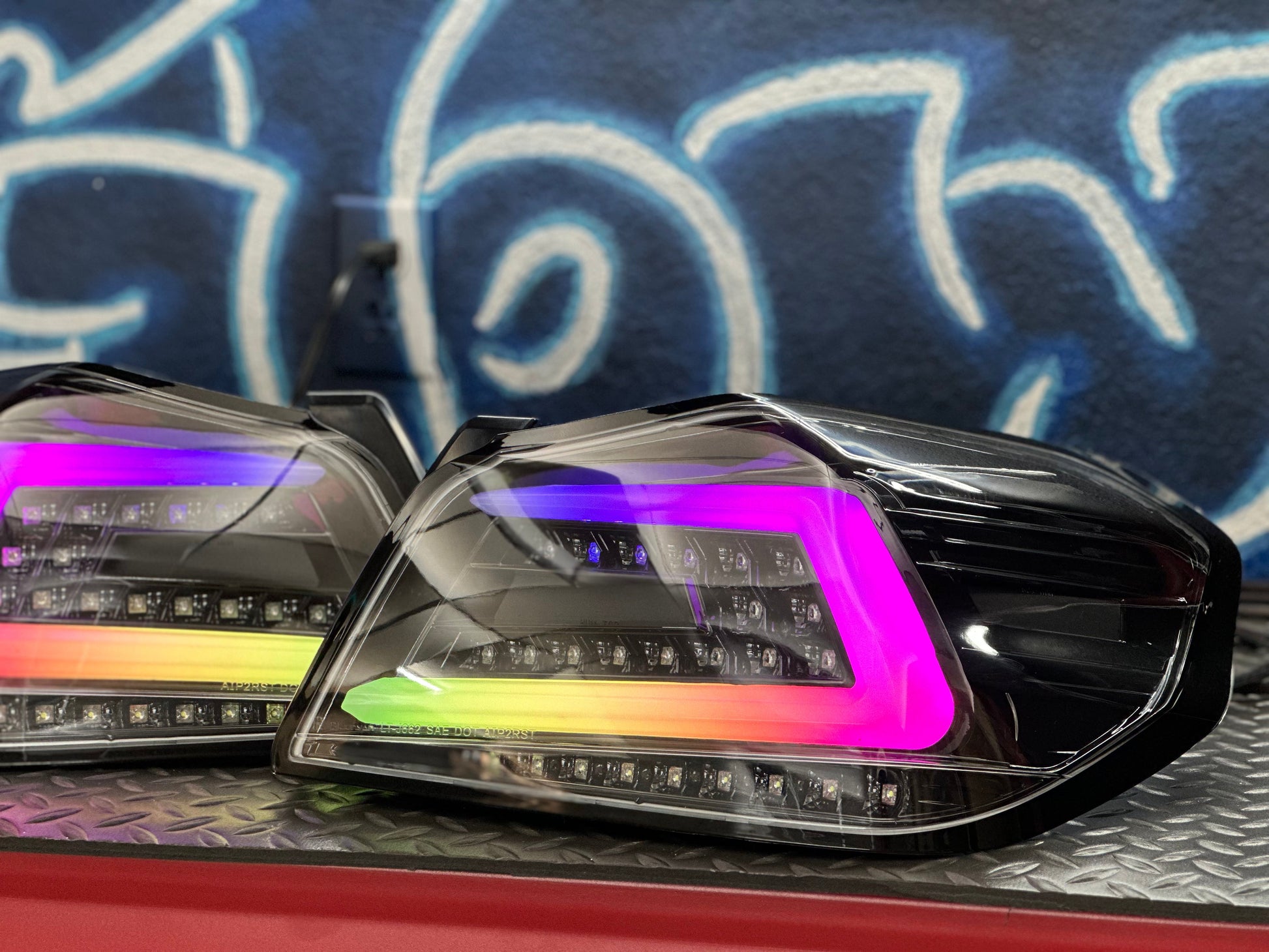 NTXGlow black RGB color-shifting tail lights for 2015-2021 Subaru WRX/STI, showing illuminated lights on a vehicle.