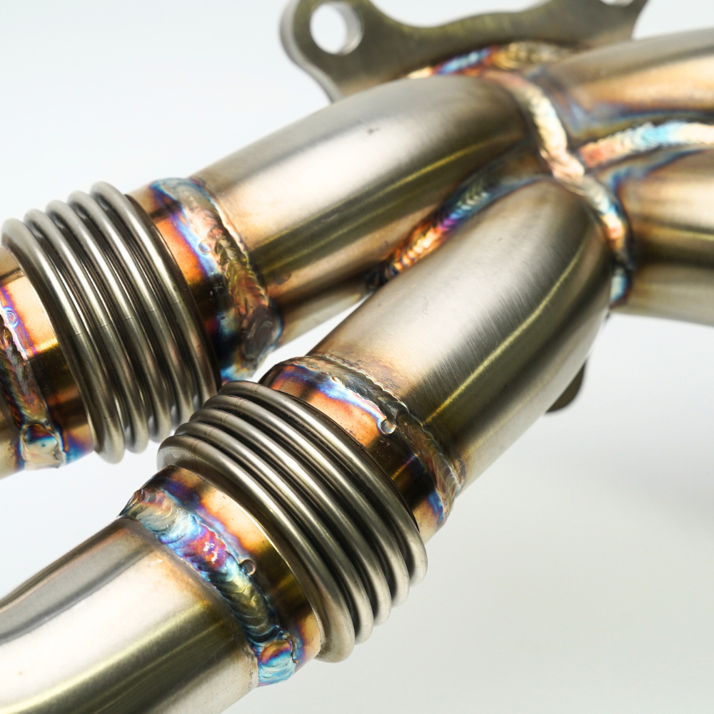 JDMuscle 22-25 WRX unequal length exhaust header for manual and CVT models, shown in black finish with mounting components.