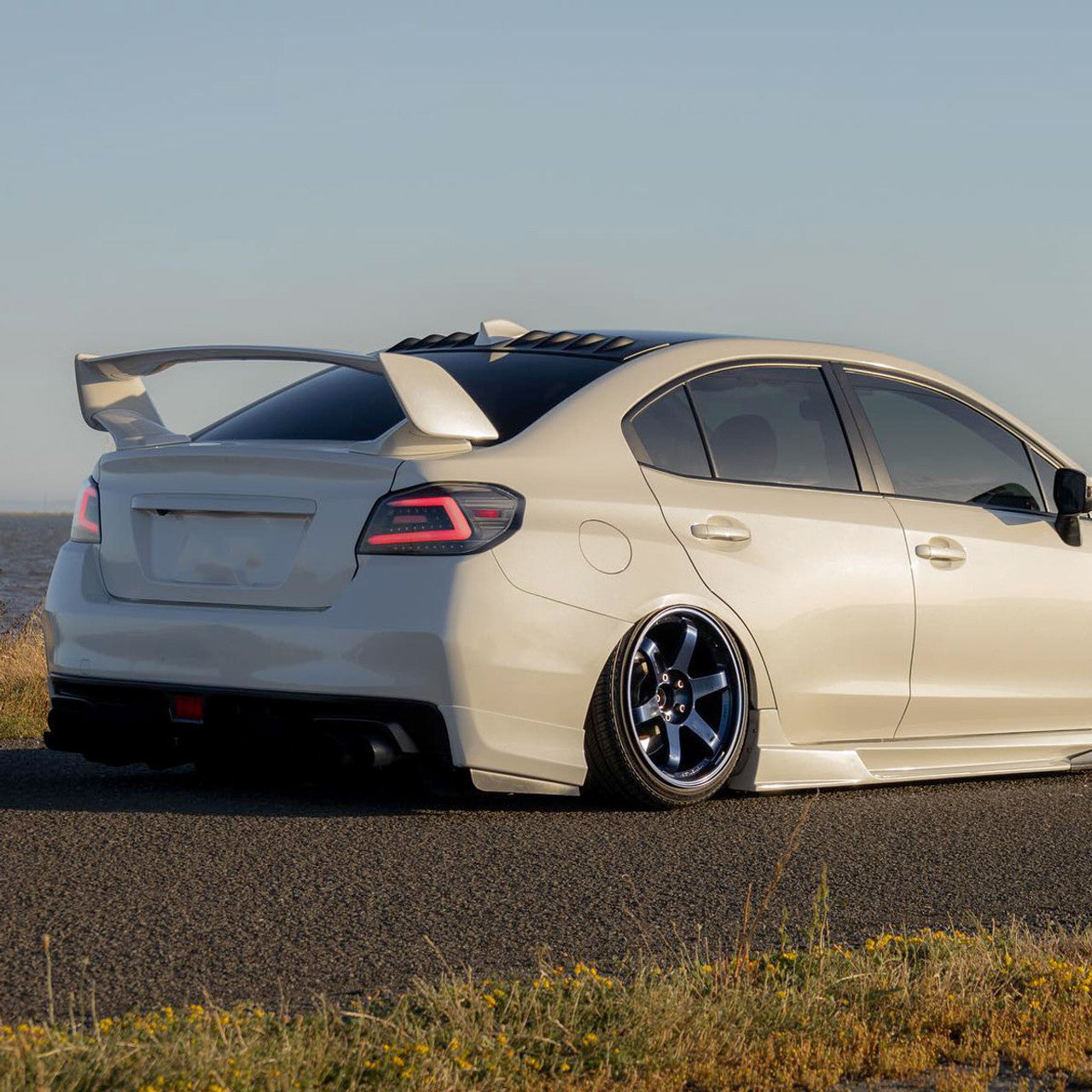NTXGlow Spec-D LED tail lights with black housing for 2015-2021 Subaru WRX and STI, featuring sleek red and clear lenses.