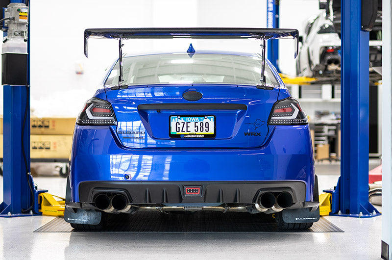 OLM Evolution tail lights with clear lenses, black bases, and white bars for 2015-2021 Subaru WRX and STI models.