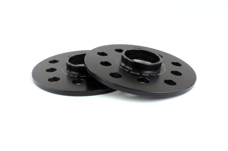 Black PERRIN 7mm wheel spacers for Subaru WRX, STI, Outback, Legacy, and Forester, shown on a vehicle wheel.