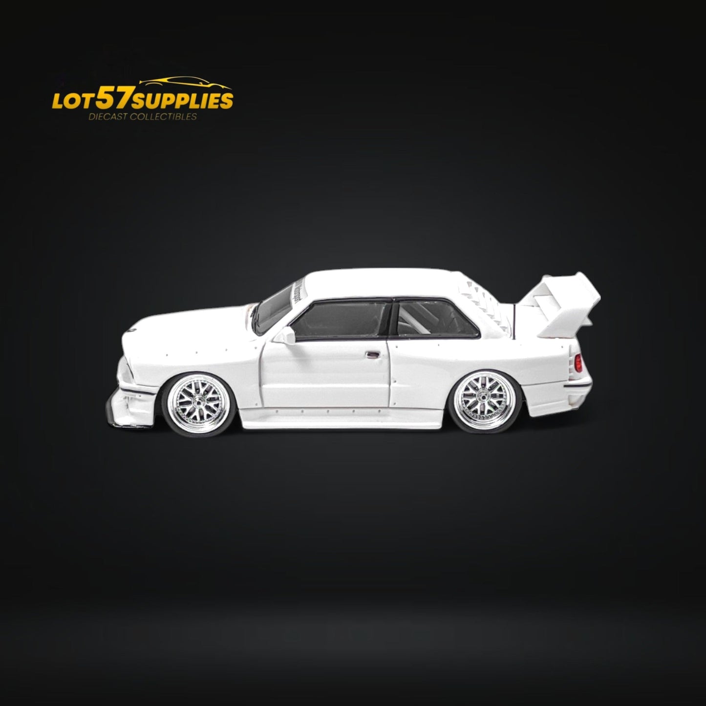 White 1:64 scale BMW E30 wide-body diecast model by Lot57Supplies Diecast Shop, detailed miniature car with wide-body design.