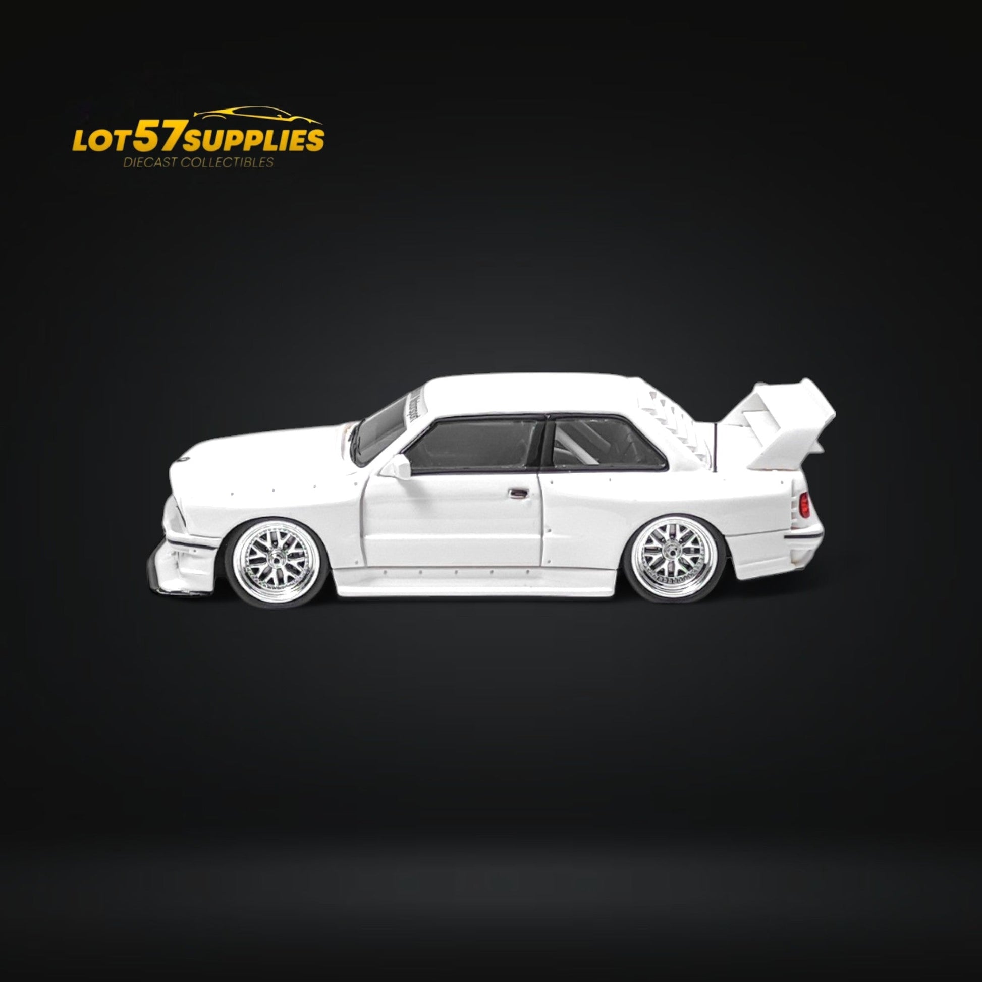 White 1:64 scale BMW E30 wide-body diecast model by Lot57Supplies Diecast Shop, detailed miniature car with wide-body design.
