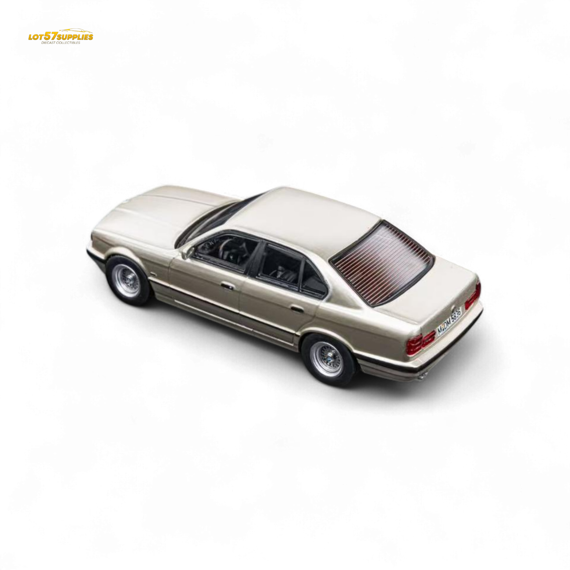 Detailed image of a gold BMW E34 5-Series sedan diecast model by Lot57Supplies, featuring cashmere and beagle design in 1:64 scale.