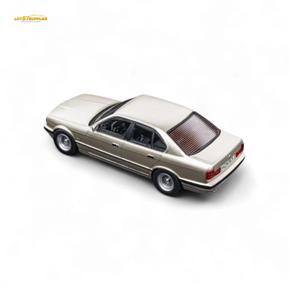 Detailed image of a gold BMW E34 5-Series sedan diecast model by Lot57Supplies, featuring cashmere and beagle design in 1:64 scale.