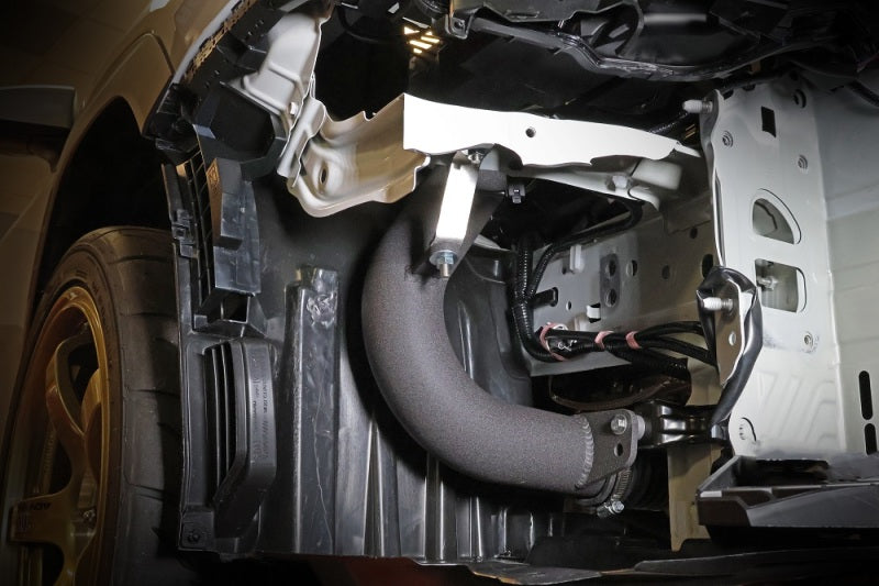 JDMuscle Perrin 22-25 WRX black cold air intake system installed in a vehicle, showcasing the sleek intake tube and filter.