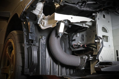 JDMuscle Perrin 22-25 WRX black cold air intake system installed in a vehicle, showcasing the sleek intake tube and filter.