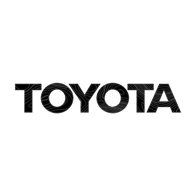 Carbonized gray Toyota Topo front grille emblem kit for 2024+ Land Cruiser and 2007-2014 FJ Cruiser, shown on rear tailgate.