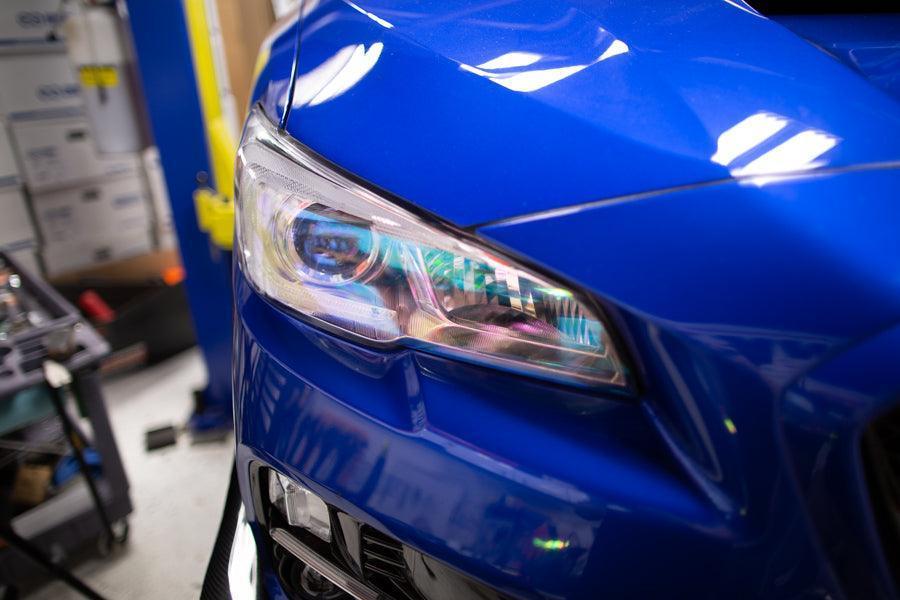 Chameleon headlight overlays for 2015-2020 Subaru WRX/STI by StickerFab, showing colorful reflective lens covers on car headlights.