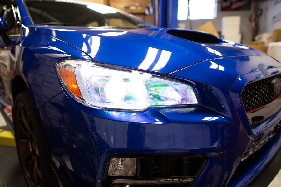 Chameleon headlight overlays on 2015-2020 Subaru WRX/STI headlights, featuring vibrant, color-shifting design from StickerFab.