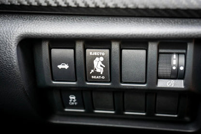 Vinyl Ejecto Seato blank button cover for 2022-2025 Subaru WRX interior, designed by StickerFab, shown on car dashboard.