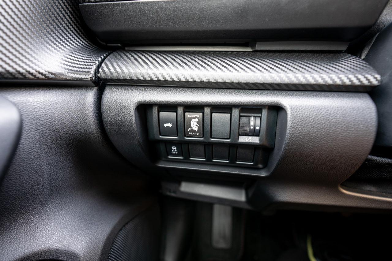 Vinyl Ejecto Seato blank button cover for 2022-2025 Subaru WRX interior, designed by StickerFab, shown on car dashboard.