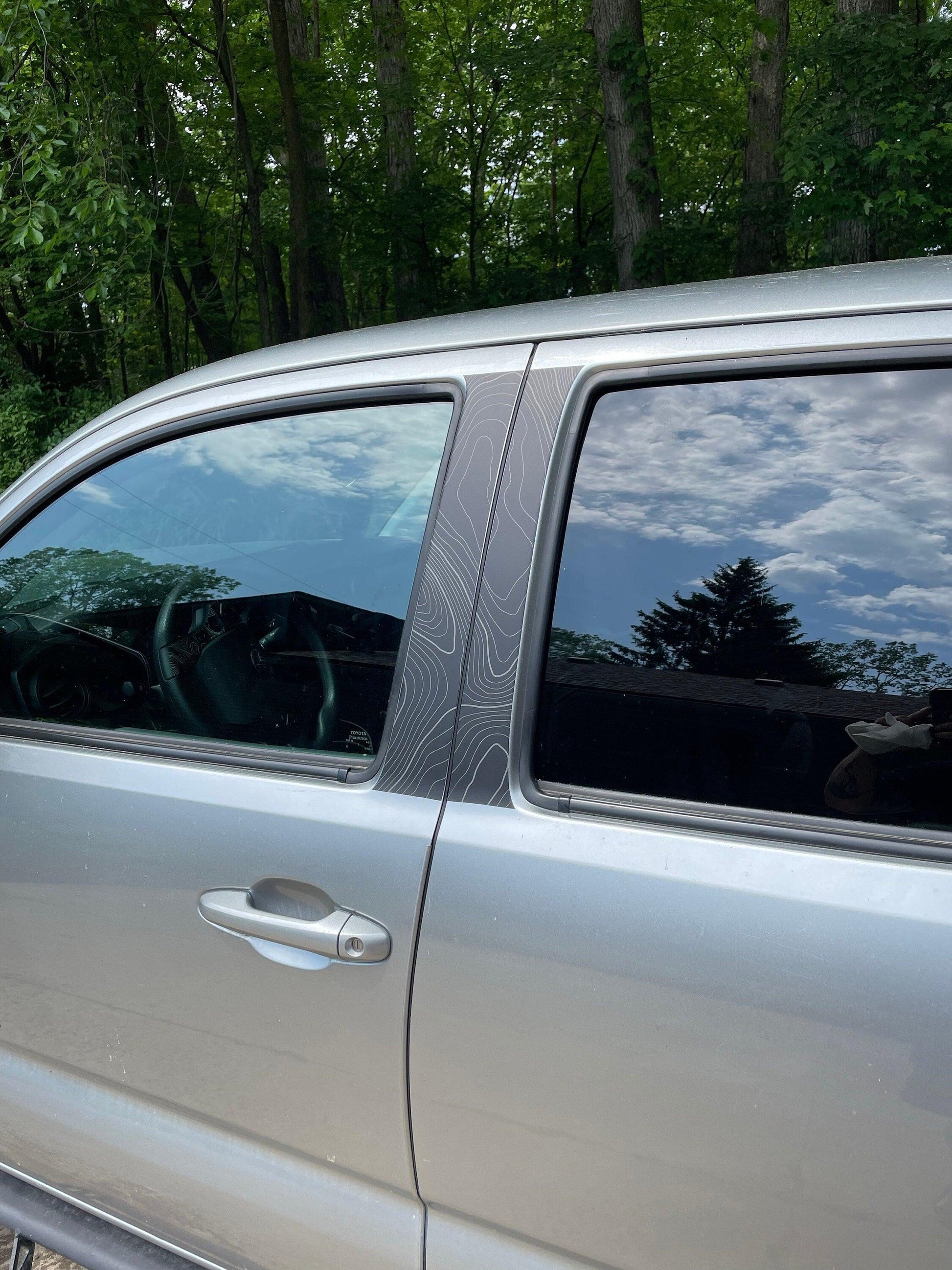 Vinyl exterior Topo B Pillar overlays for 2016-2023 Tacoma Double Cab by StickerFab, shown on vehicle pillars.