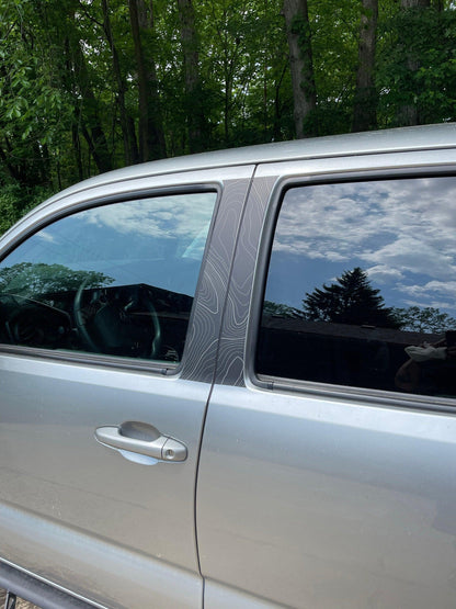 Vinyl exterior Topo B Pillar overlays for 2016-2023 Tacoma Double Cab by StickerFab, shown on vehicle pillars.