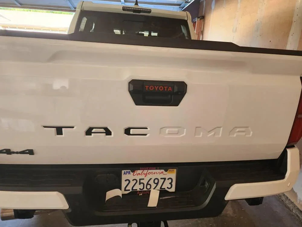 Vinyl TACOMA tailgate inlay letters for 2024+ Toyota Tacoma, exterior decal by StickerFab, shown on truck tailgate.