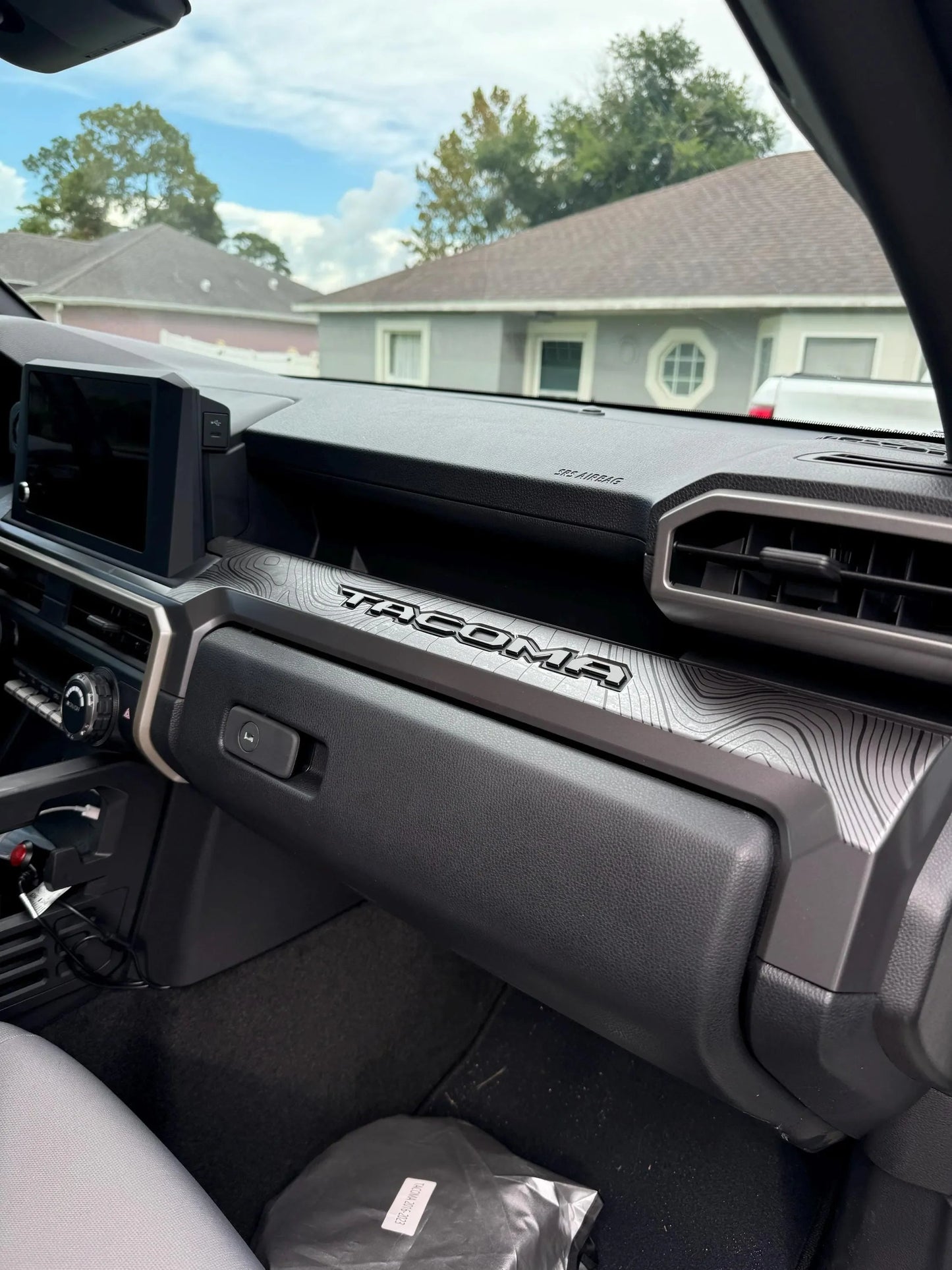 3-piece vinyl topographic map dash overlays for 2024+ Toyota Tacoma interior, featuring detailed topography design by StickerFab