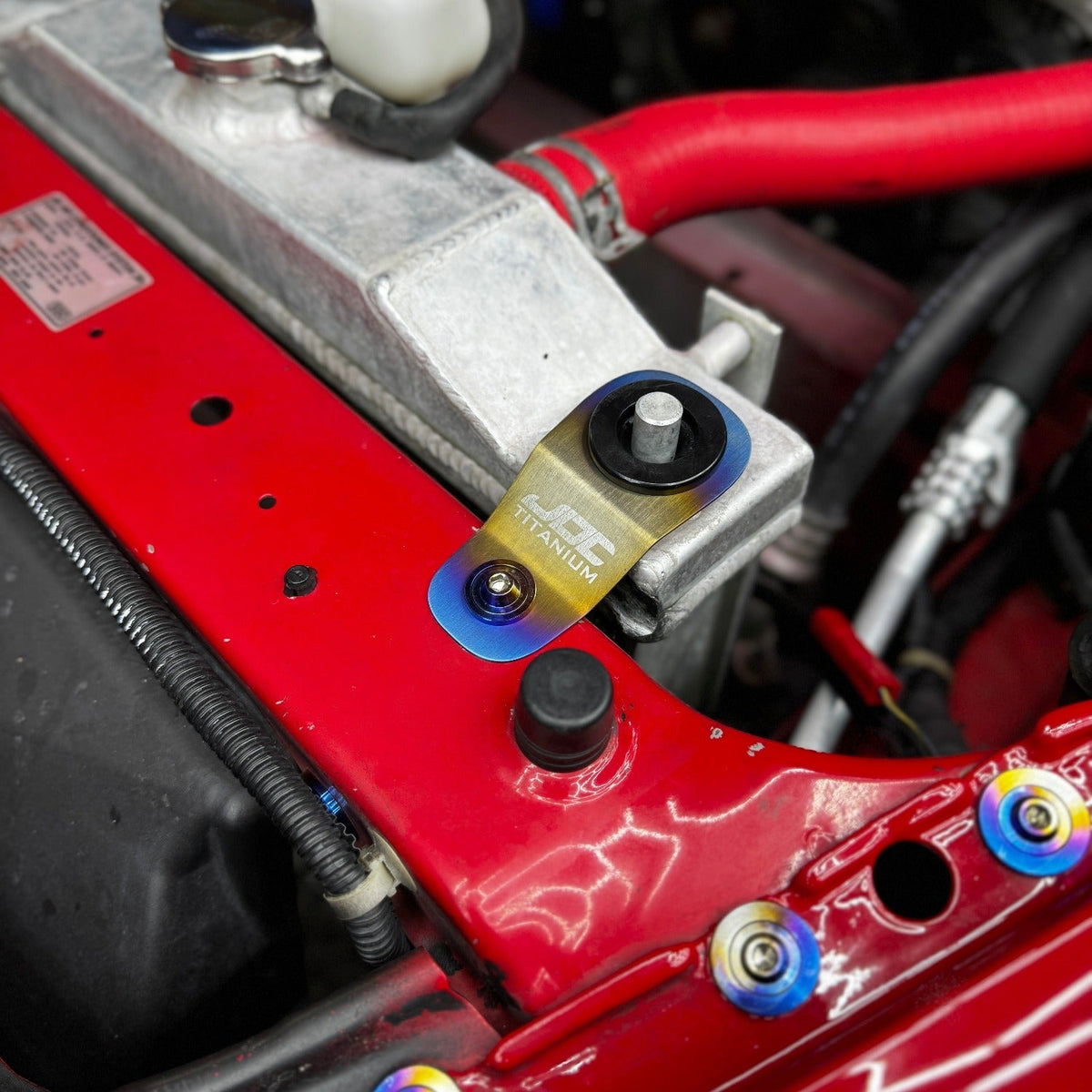 JDC Titanium Radiator Stay Bracket for Honda S2000 and EK, EM, EJ models, made by JD Customs U.S.A, visible in the image.