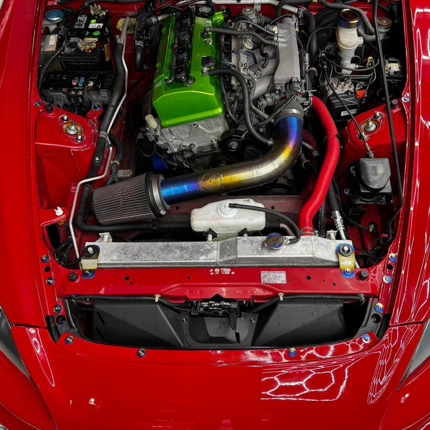 JDC Titanium Radiator Stay Bracket for Honda S2000, EK, EM, EJ models, made by JD Customs U.S.A, shown mounted on engine bay.