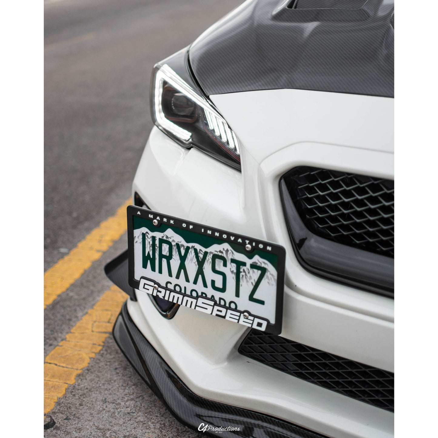JDMuscle VR Style carbon fiber front bumper lip for 2015-2017 Subaru WRX/STI, installed on the front of the vehicle.