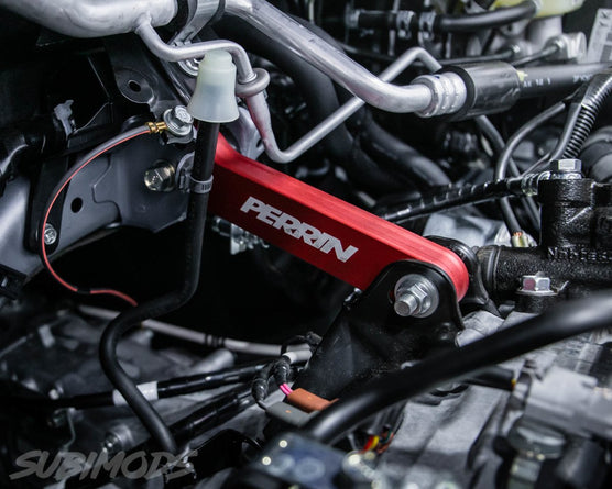 Red Perrin pitch stop mount for 2002-2022 Subaru WRX, STI, LGT, and FXT, shown in a close-up view of the engine bay.