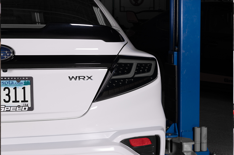OLM Spec-AR LED taillights with smoke lens, black base, and white bar for 2022+ Subaru WRX, showcasing sleek tail light design.