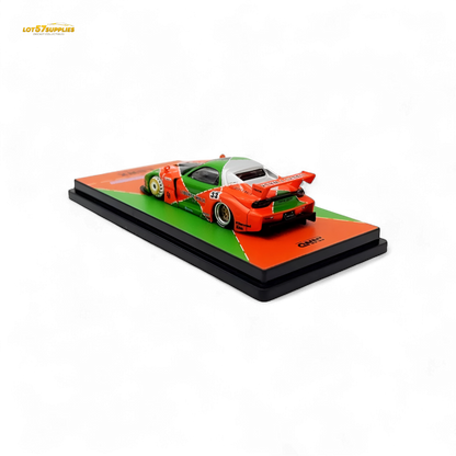 Orange and green Inno64 Mazda RX-7 LBWK diecast model, detailed 1:64 scale car with Mazda branding.