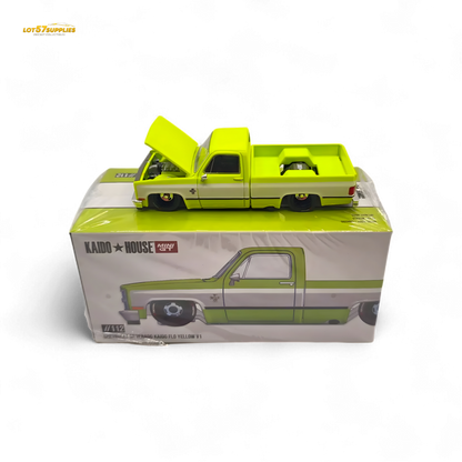 Mini GT x Kaido House Chevrolet Silverado FLO YELLOW diecast model in 1:64 scale, yellow Chevrolet pickup truck with detailed features.