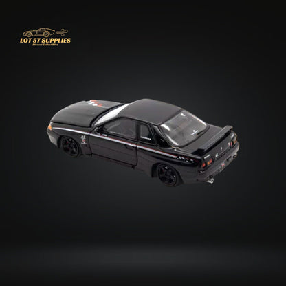 Nissan Skyline R32 GT-R Nismo S-Tune diecast model in 1:64 scale, detailed silver Nissan car with blue accents and racing decals.