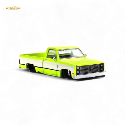Mini GT x Kaido House Chevrolet Silverado diecast truck in yellow, 1:64 scale, featuring detailed design and vibrant color.