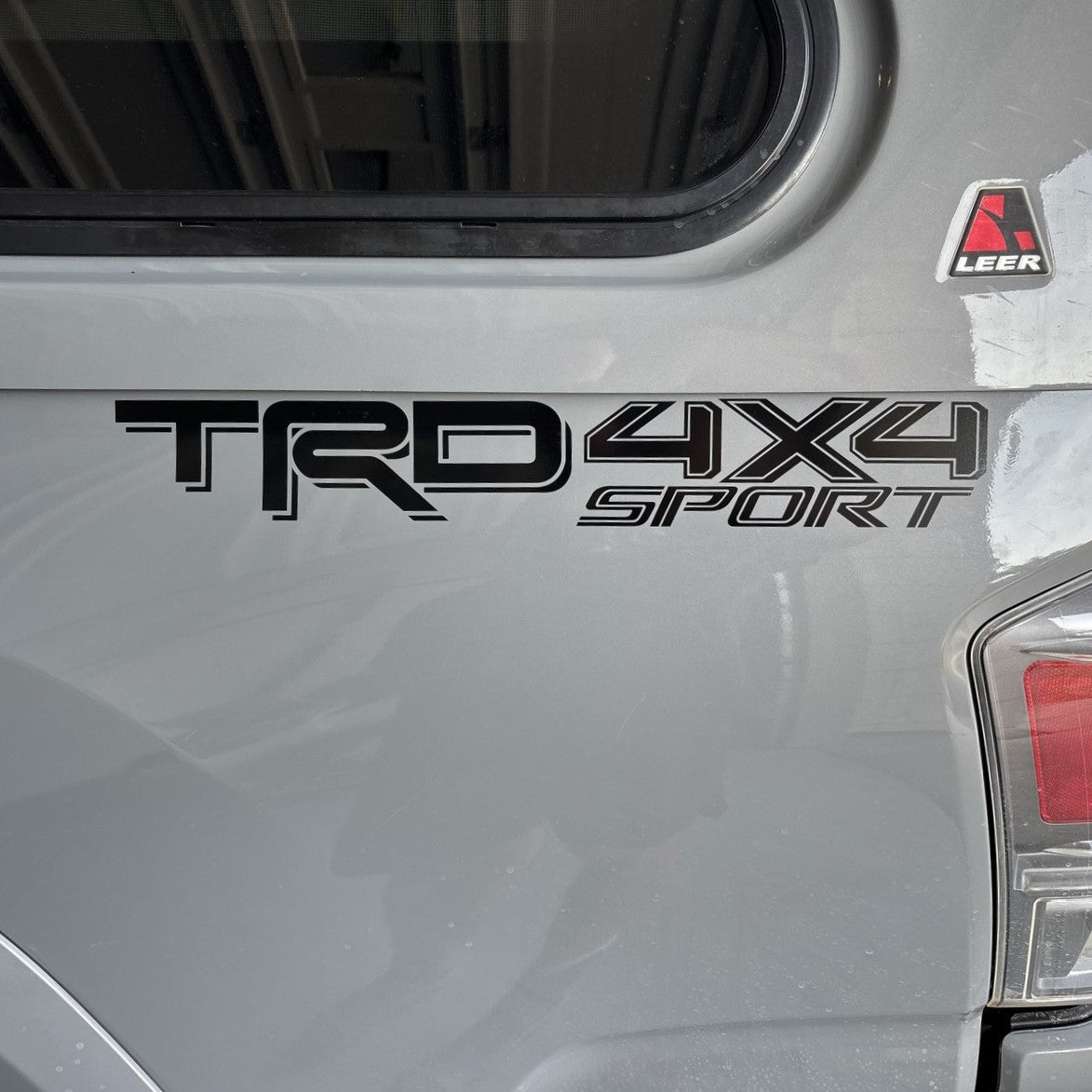 Black TRD 4x4 Sport truck bedside decals on gray background for Toyota Tacoma, Tundra, and Hilux vehicles.