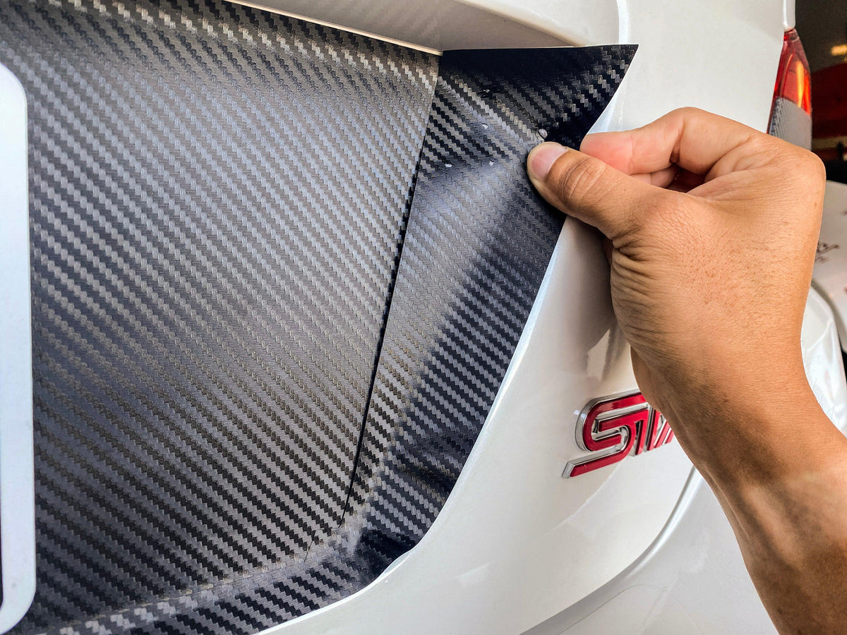 Black 3D carbon fiber style license plate panel overlay for 2015-2020 Subaru WRX and STI by StickerFab, exterior body accessory.