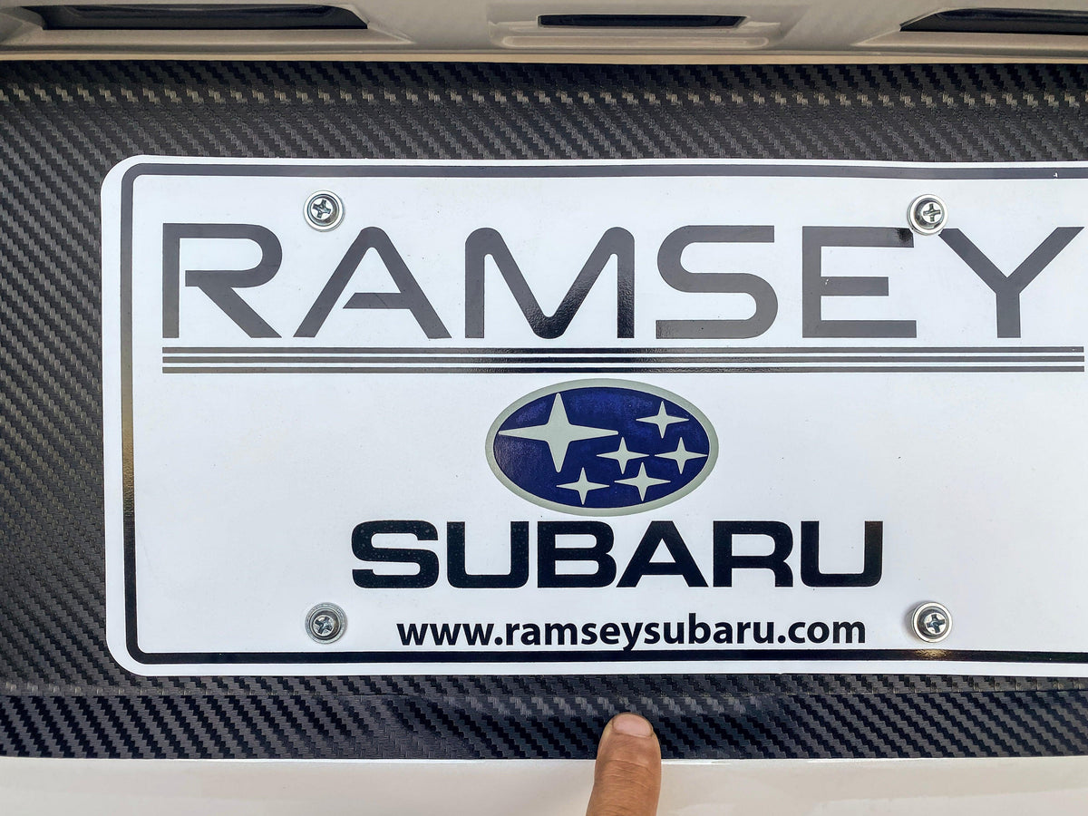 Black 3D carbon fiber license plate panel overlay for 2015-2020 Subaru WRX and STI, by StickerFab, exterior body accessory.