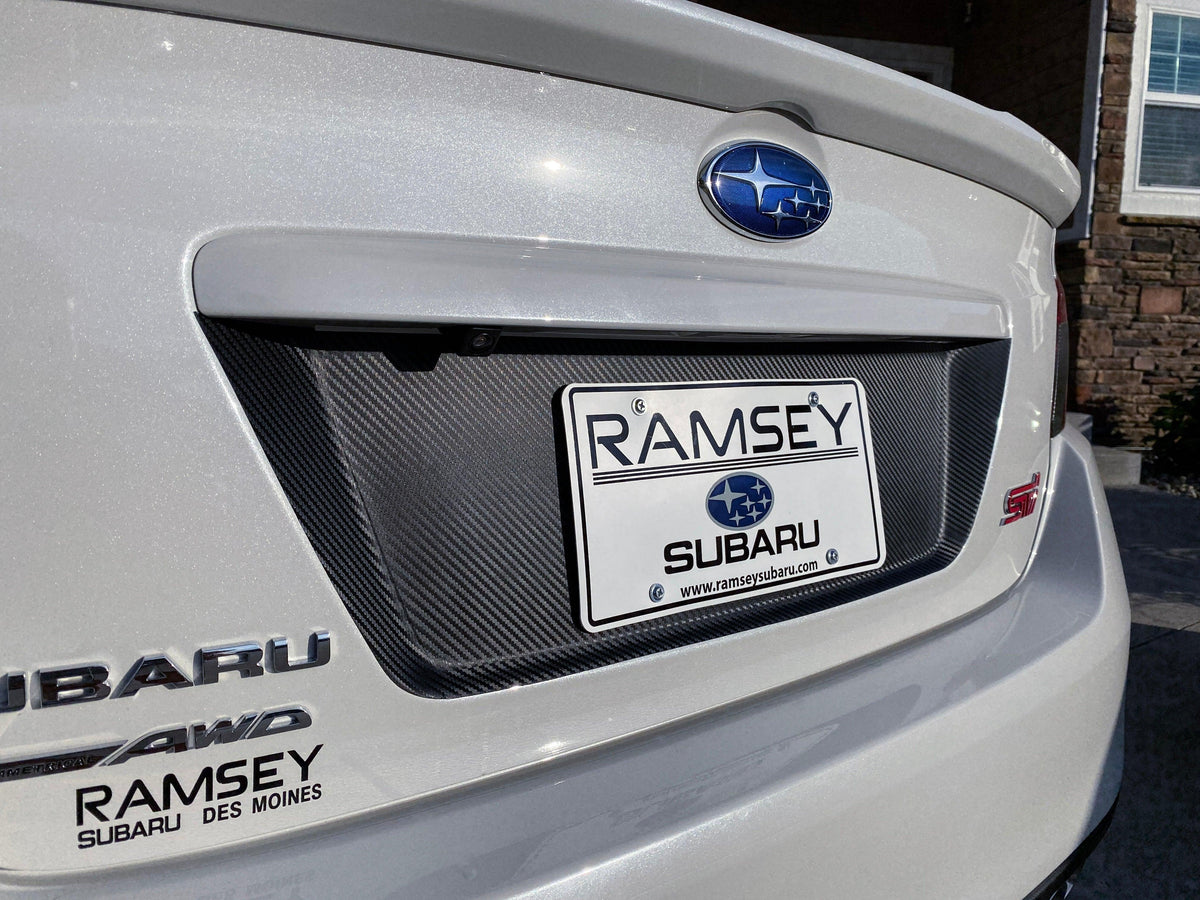 StickerFab 3D carbon license plate panel overlays on a 2015-2020 Subaru WRX STI, showcasing black-out exterior body accessories.