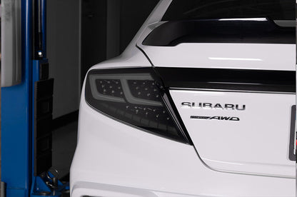 OLM Spec-AR LED taillights with smoke lens, black base, and white bar installed on a 2022+ Subaru WRX.